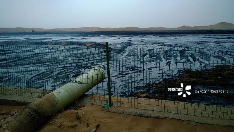 腾格里沙漠腹地现巨型排污池 黑色管道插入沙中散发恶臭/ 视觉中国
